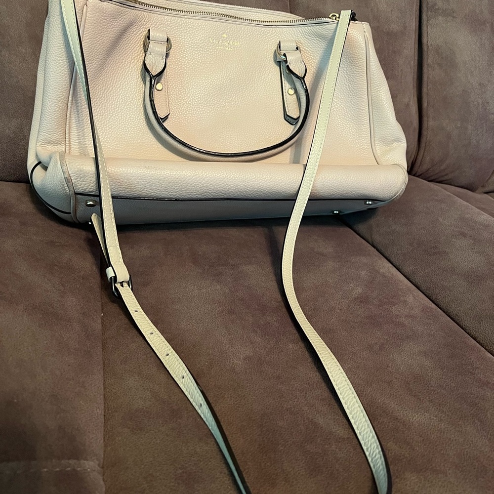 Kate Spade Cream leather tote with long strap and multiple pockets for storage.
